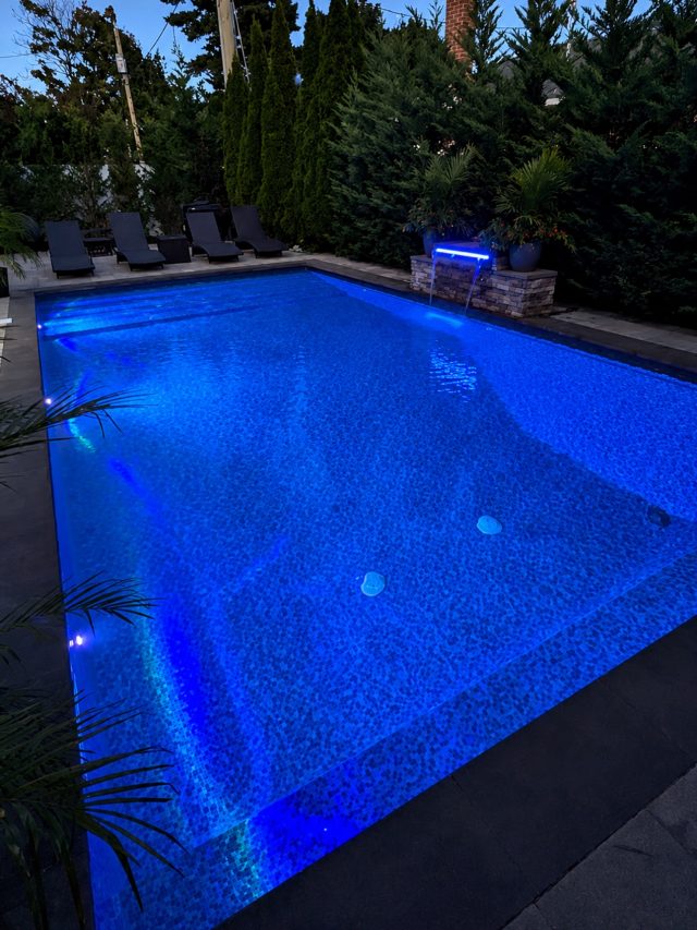 🌒🌊 Built for summer nights like this.
16x30 concrete wall vinyl liner pool featuring a full-width stadium step, deep-end bench seating, LED lighting, and a 36” sheer descent waterfall designed to bring movement and atmosphere into the space.

Finished with Cambridge Ledgestone XL masonry, mocha coping, and a Merlin Blue Point liner that gives the water its rich, vibrant tone from every angle.

Designed and built by Harbor Pool & Patio
📞 631-480-7664